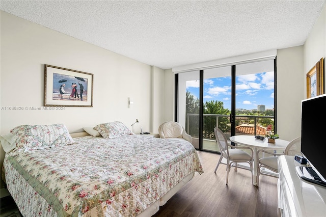 bedroom with a textured ceiling, access to exterior, a wall of windows, and dark wood-type flooring