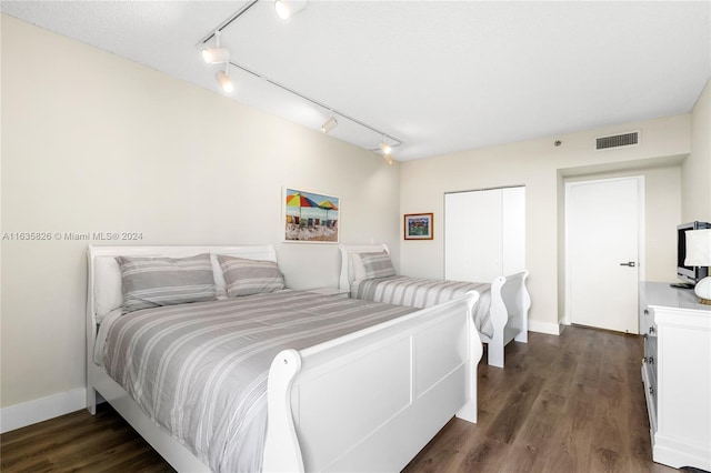 bedroom featuring dark hardwood / wood-style floors and rail lighting