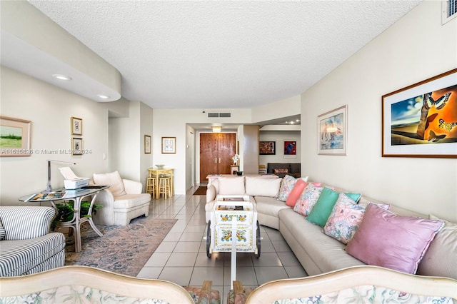 tiled living room featuring a textured ceiling