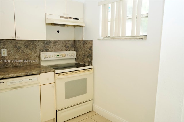 kitchen featuring light tile patterned flooring, tasteful backsplash, custom exhaust hood, and white appliances