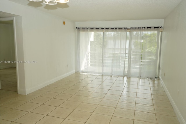 unfurnished room with light tile patterned flooring and a textured ceiling