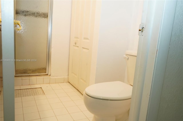 bathroom with toilet, tile patterned flooring, and walk in shower