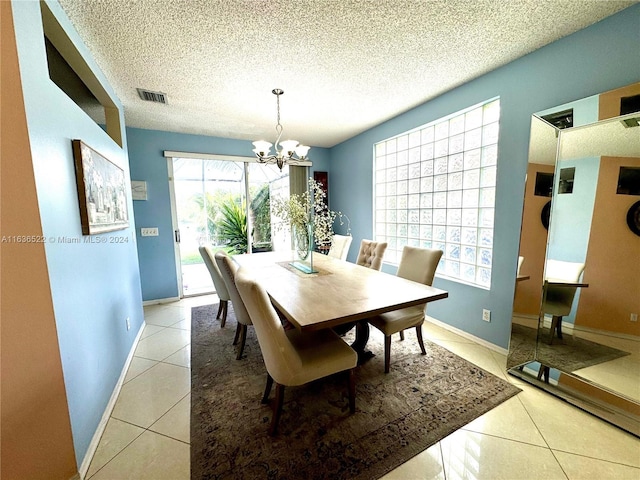 dining space featuring a chandelier, a textured ceiling, light tile patterned flooring, visible vents, and baseboards