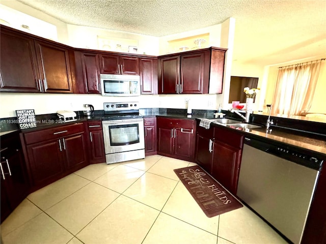 kitchen featuring reddish brown cabinets, appliances with stainless steel finishes, and a sink