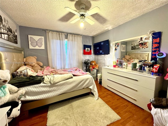 bedroom featuring ceiling fan, a textured ceiling, and wood finished floors