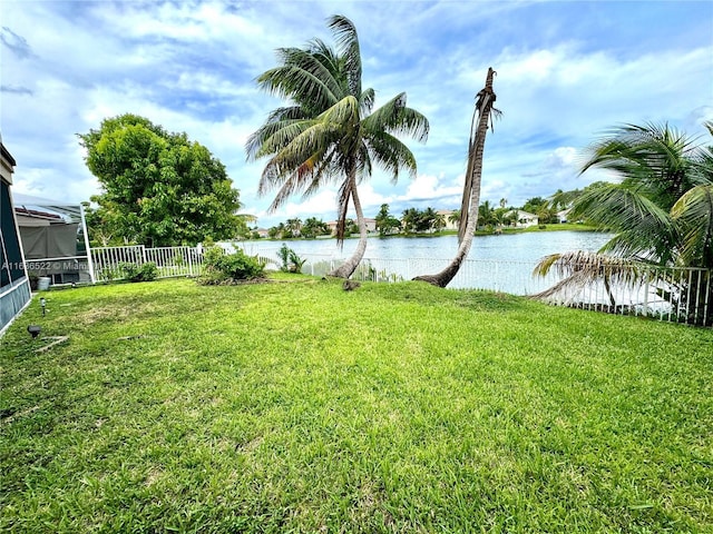 view of yard with a water view and fence