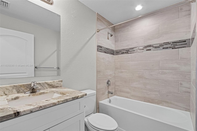 full bathroom with tiled shower / bath combo, toilet, and vanity