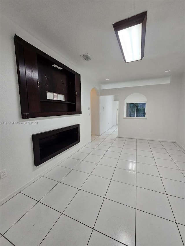 unfurnished living room featuring light tile patterned floors