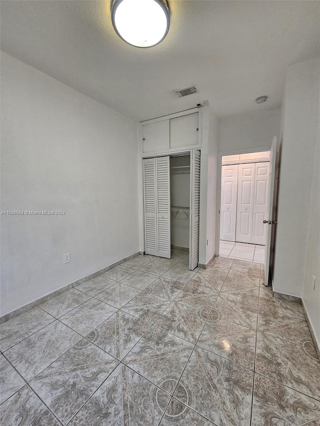 unfurnished bedroom featuring light tile patterned flooring