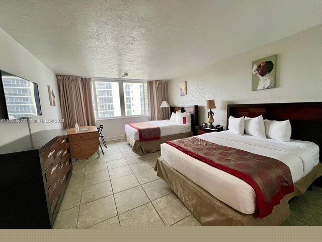 bedroom with a textured ceiling and light tile patterned floors