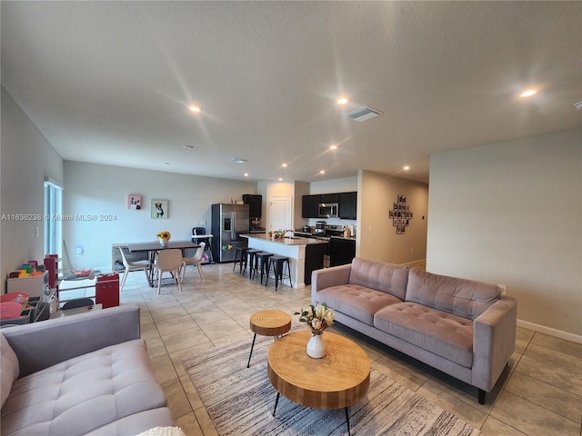 living room featuring light tile patterned floors and a textured ceiling