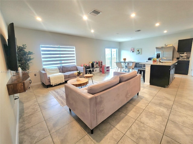 living room with light tile patterned flooring and sink