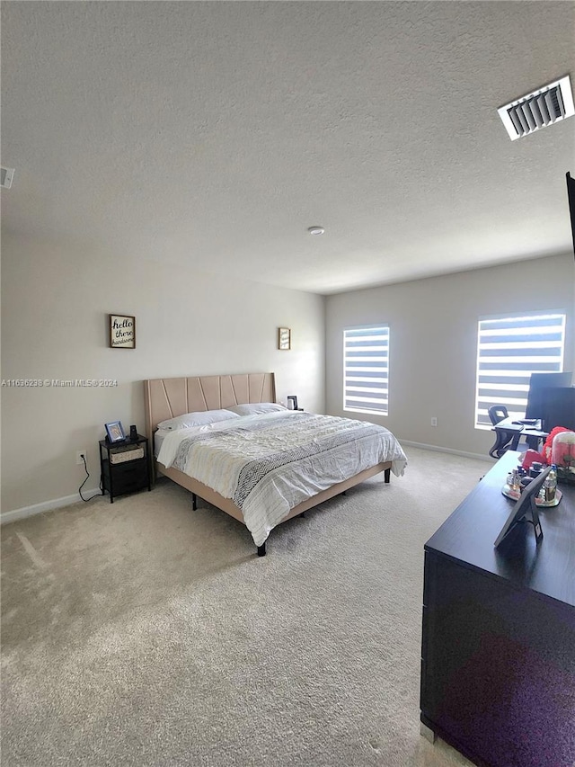 bedroom with carpet floors and a textured ceiling