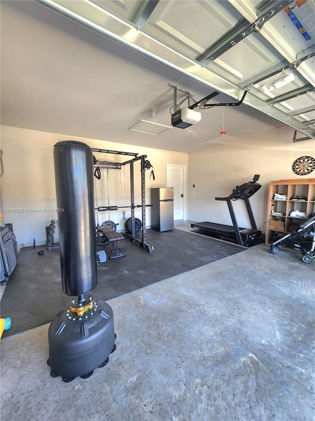 garage with a garage door opener and stainless steel fridge