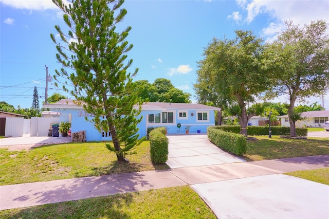 view of front of house with fence, driveway, and a front lawn