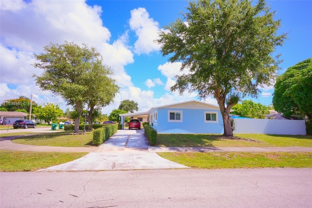 view of front facade featuring an attached carport, fence, driveway, and a front yard