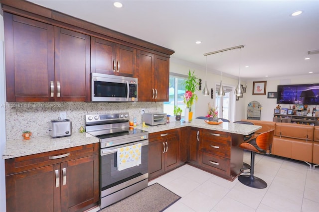 kitchen with stainless steel appliances, open floor plan, light stone counters, and decorative backsplash