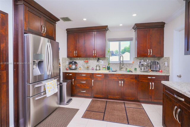 kitchen featuring sink, stainless steel fridge, backsplash, and light tile patterned flooring