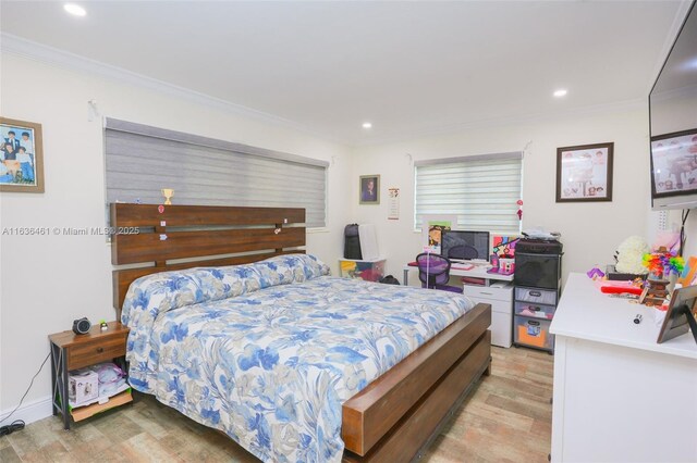 bedroom with crown molding and light wood-type flooring