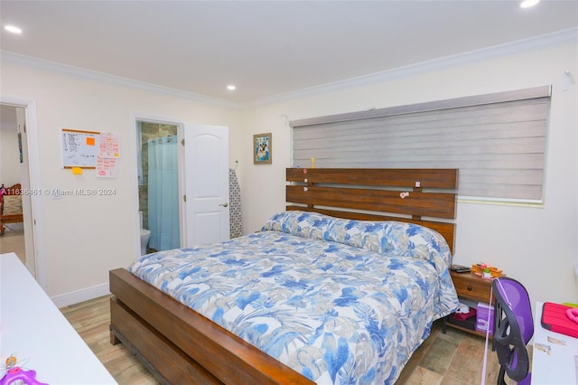 bedroom featuring hardwood / wood-style floors, crown molding, and ensuite bath