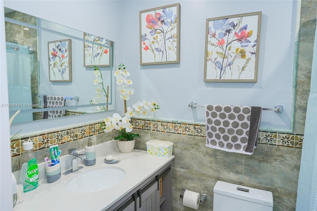 bathroom with tile walls, walk in shower, toilet, and vanity