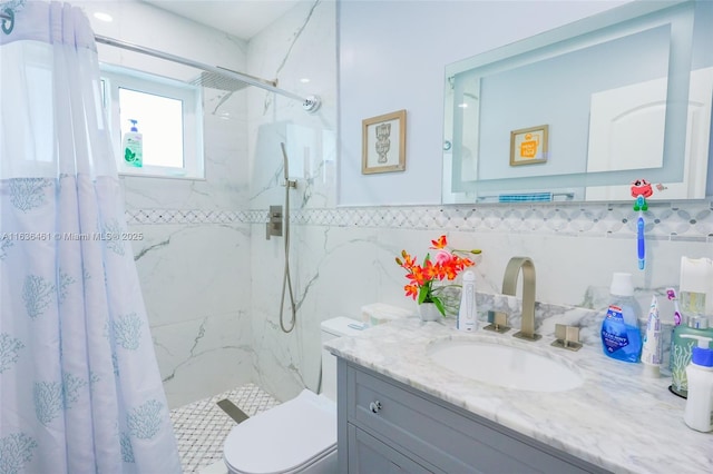 bathroom with toilet, tile walls, a marble finish shower, and vanity