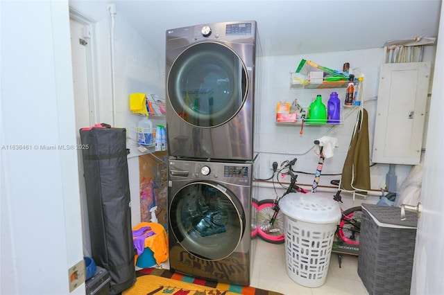 laundry area featuring laundry area, stacked washer and dryer, tile patterned flooring, and electric panel