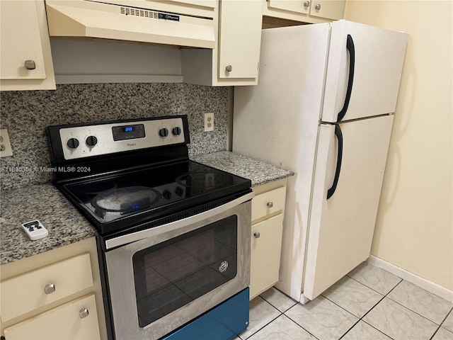 kitchen with tasteful backsplash, freestanding refrigerator, stainless steel range with electric cooktop, under cabinet range hood, and baseboards