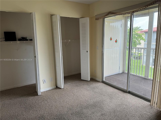 unfurnished bedroom featuring access to outside, a closet, carpet, and baseboards