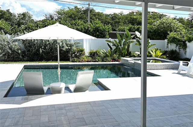 view of swimming pool featuring a patio and an in ground hot tub