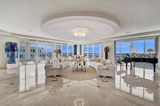 tiled living room featuring a wall of windows and a raised ceiling