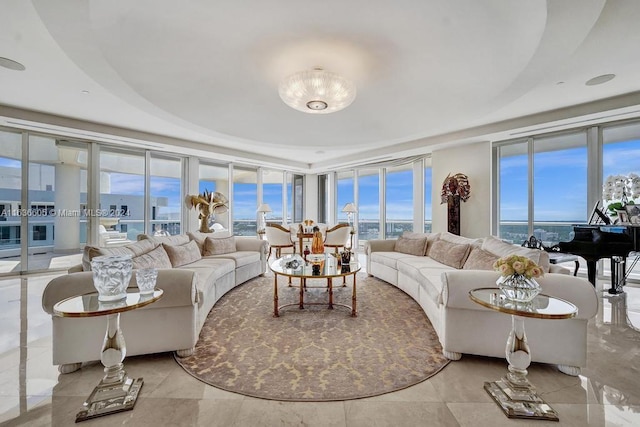 living room featuring floor to ceiling windows, light tile patterned floors, and a tray ceiling