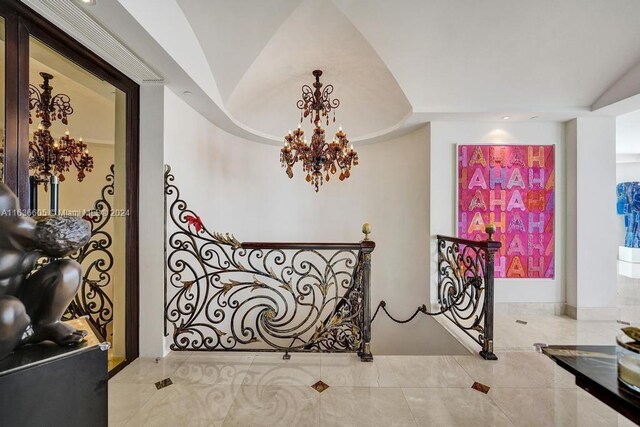 hall with tile patterned flooring and a notable chandelier