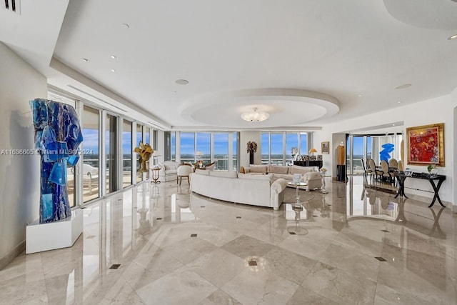 living room with a wall of windows and a tray ceiling