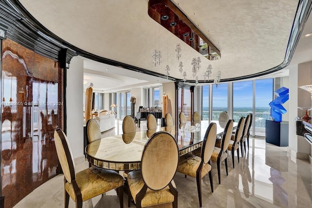 dining room featuring a wall of windows, a water view, and a tray ceiling