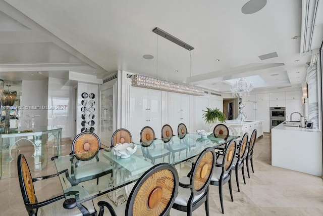 tiled dining space featuring sink, an inviting chandelier, and a tray ceiling