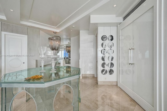 tiled entryway featuring a tray ceiling