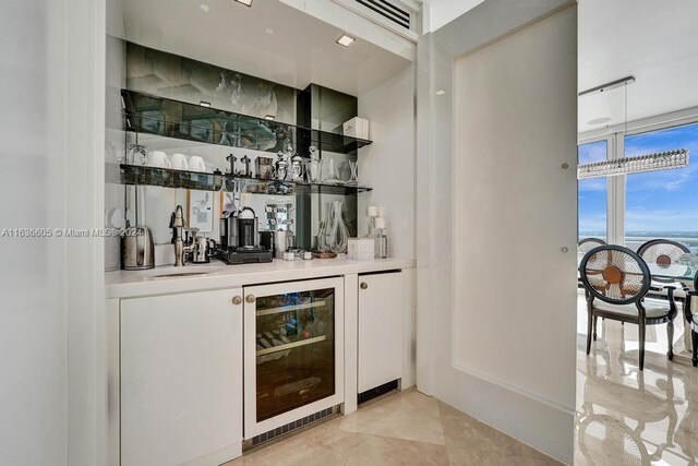 bar featuring white cabinets, beverage cooler, and light tile patterned floors