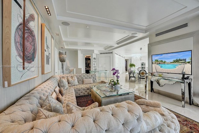 living room with light tile patterned floors and a tray ceiling