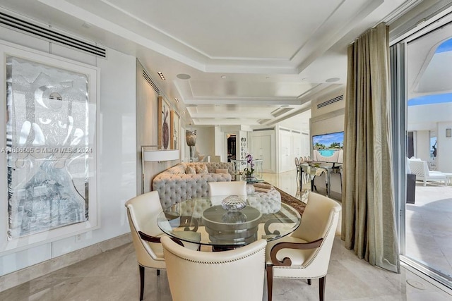 dining room featuring a raised ceiling and light tile patterned floors