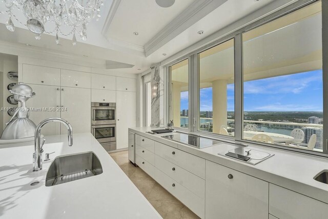 kitchen with white cabinetry, crown molding, sink, stainless steel double oven, and light tile patterned floors