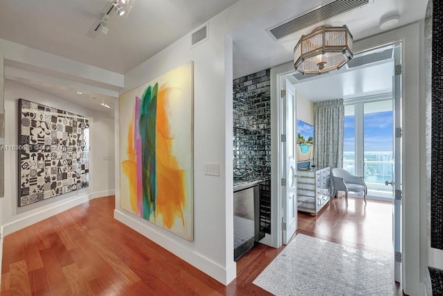 hallway featuring hardwood / wood-style floors and rail lighting