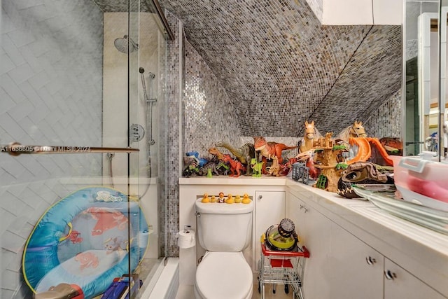 full bathroom with vaulted ceiling, vanity, tile walls, and toilet