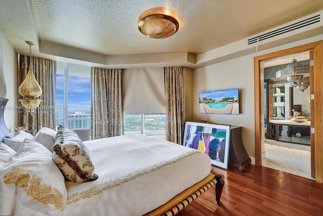 bedroom with wood-type flooring and a textured ceiling