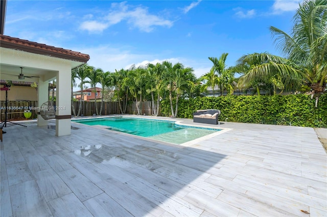 view of swimming pool featuring ceiling fan and a patio area