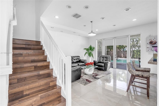 staircase with light tile patterned flooring and french doors