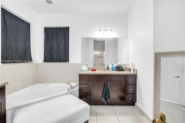 bathroom featuring vanity, tiled bath, and tile patterned flooring