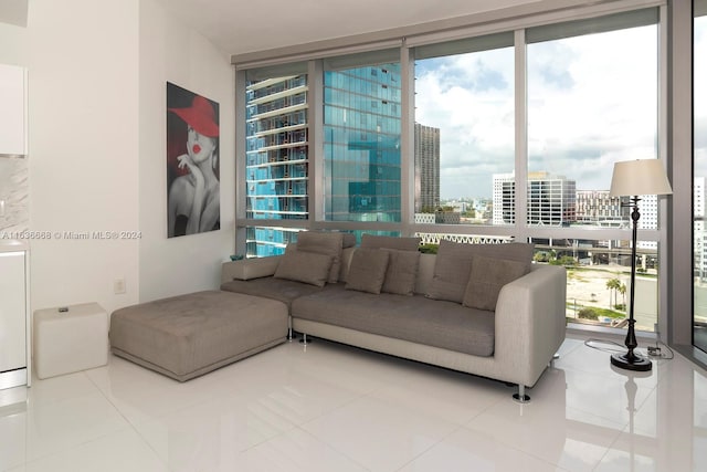 living room with a wall of windows, tile patterned floors, and a city view