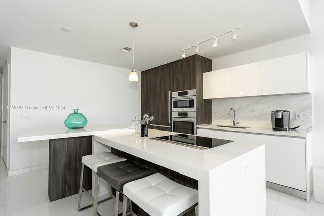 kitchen featuring sink, dark brown cabinets, white cabinetry, stainless steel double oven, and black electric stovetop