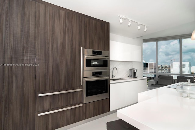 kitchen featuring light countertops, modern cabinets, a sink, and white cabinets